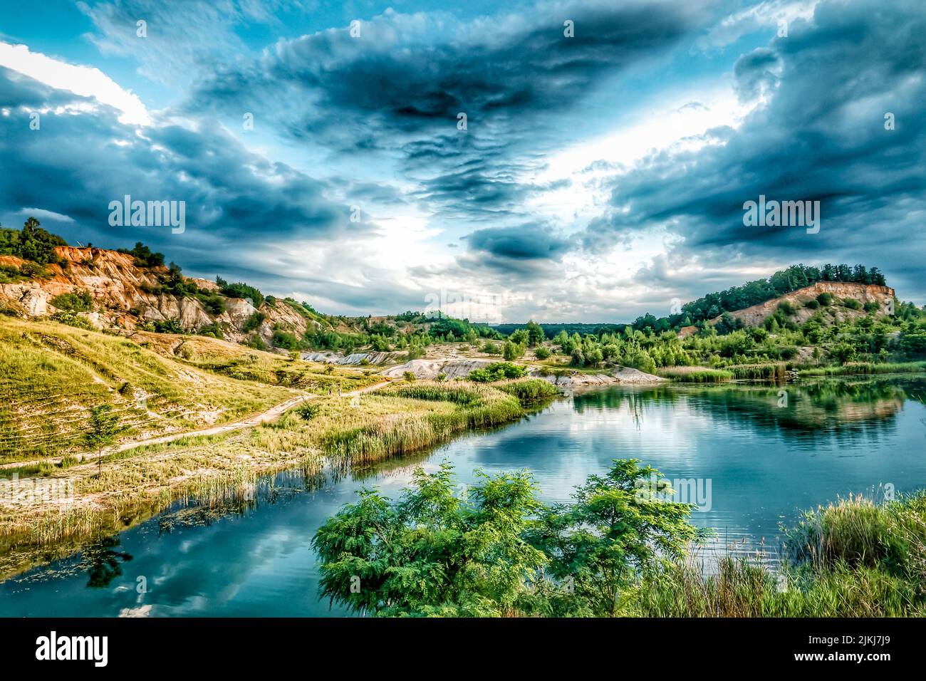 Eine malerische Aussicht auf die Hügel und den Fluss mit Reflexion gegen den bewölkten Himmel Stockfoto