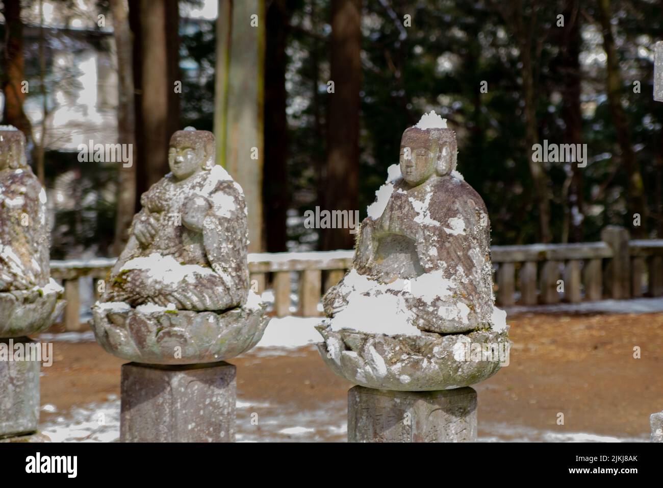 Eine Reihe alter steinerner Buddhastatuen in Japan im Winter Stockfoto