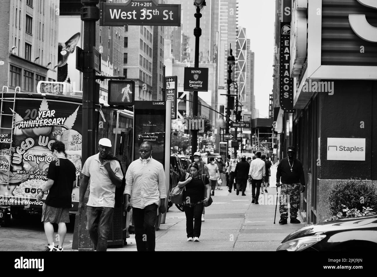 Eine Graustufenaufnahme von Menschen, die in den Straßen von Midtown Manhattan, NYC, spazieren Stockfoto