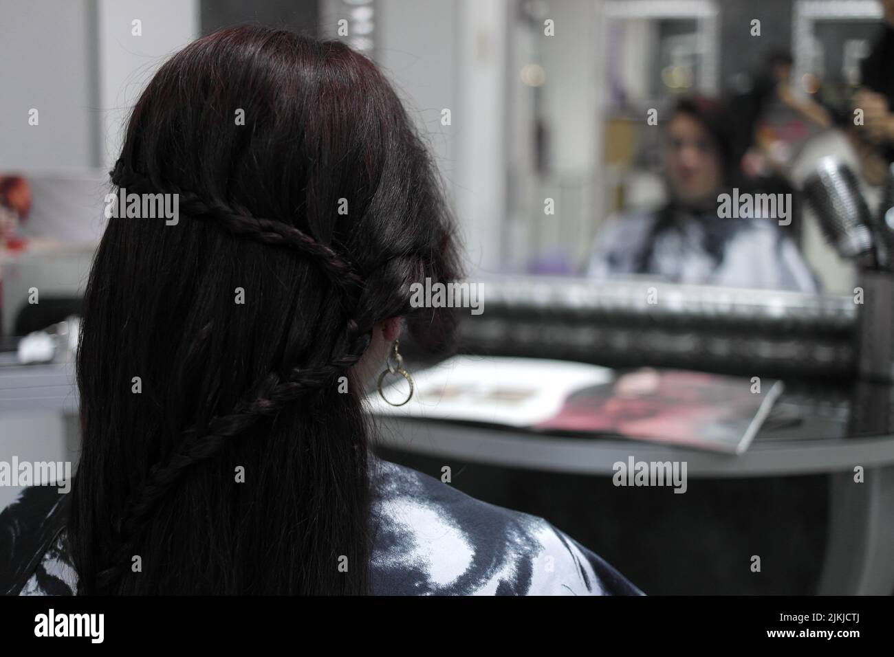 Ein flacher Fokus einer Frau in einem Friseursalon mit ausgefallener geflochtener Frisur Stockfoto