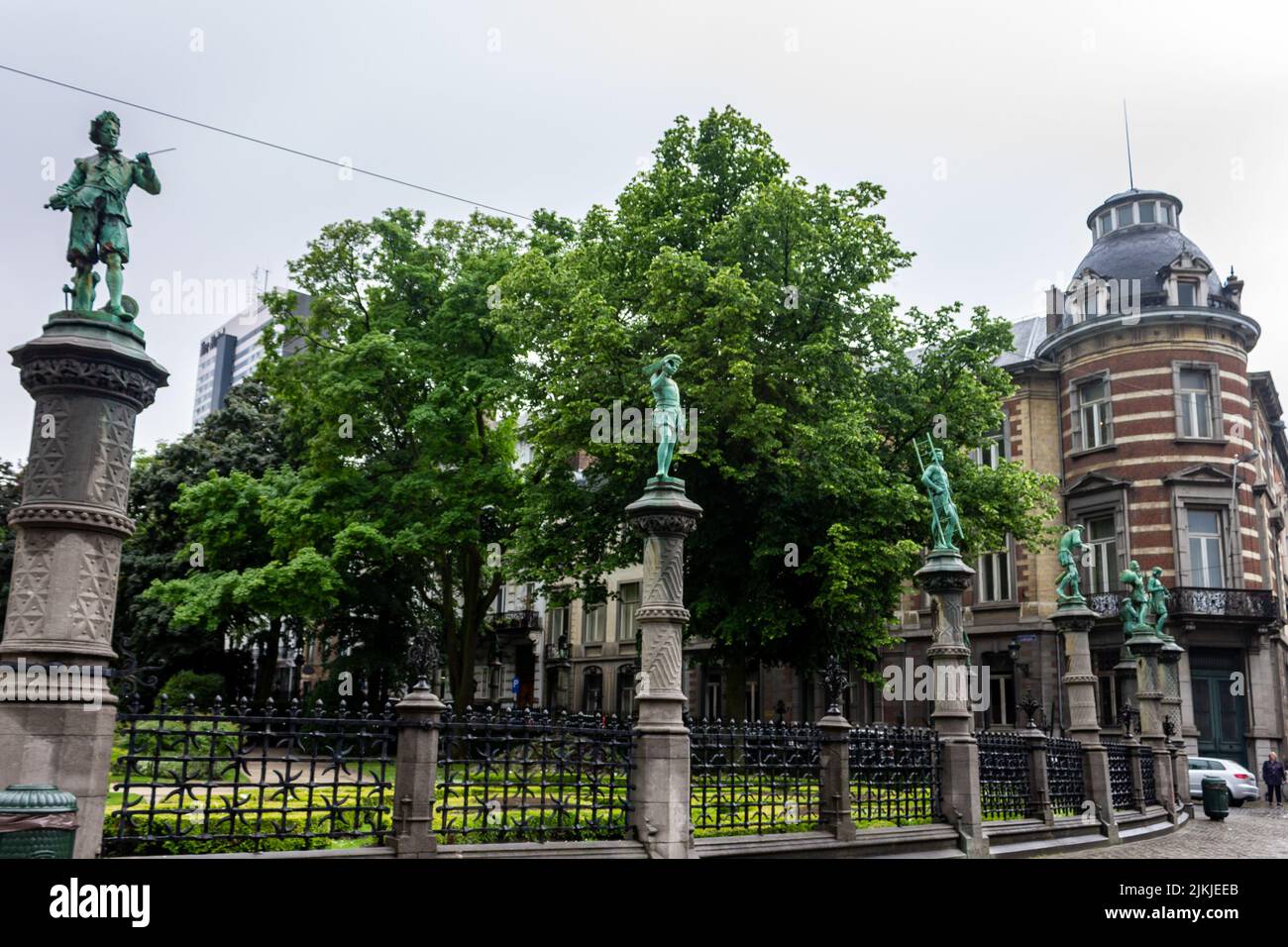 Eine schöne Aufnahme der Zäune des Petit Sablon Square mit blauen Statuen und Bäumen in Brüssel, Belgien Stockfoto