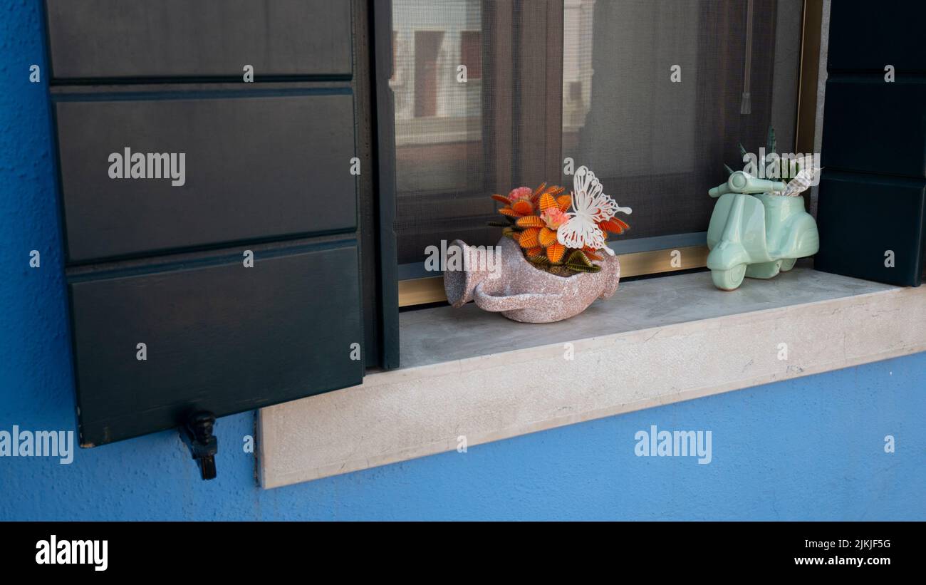 Zwei Pflanzen in einzigartigen Töpfen auf der Fensterbank eines Hauses Stockfoto