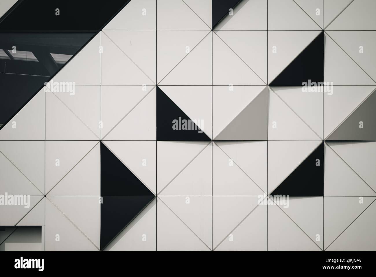 Eine Nahaufnahme von schwarzen und weißen dreieckigen Fliesen an einer Wand Stockfoto