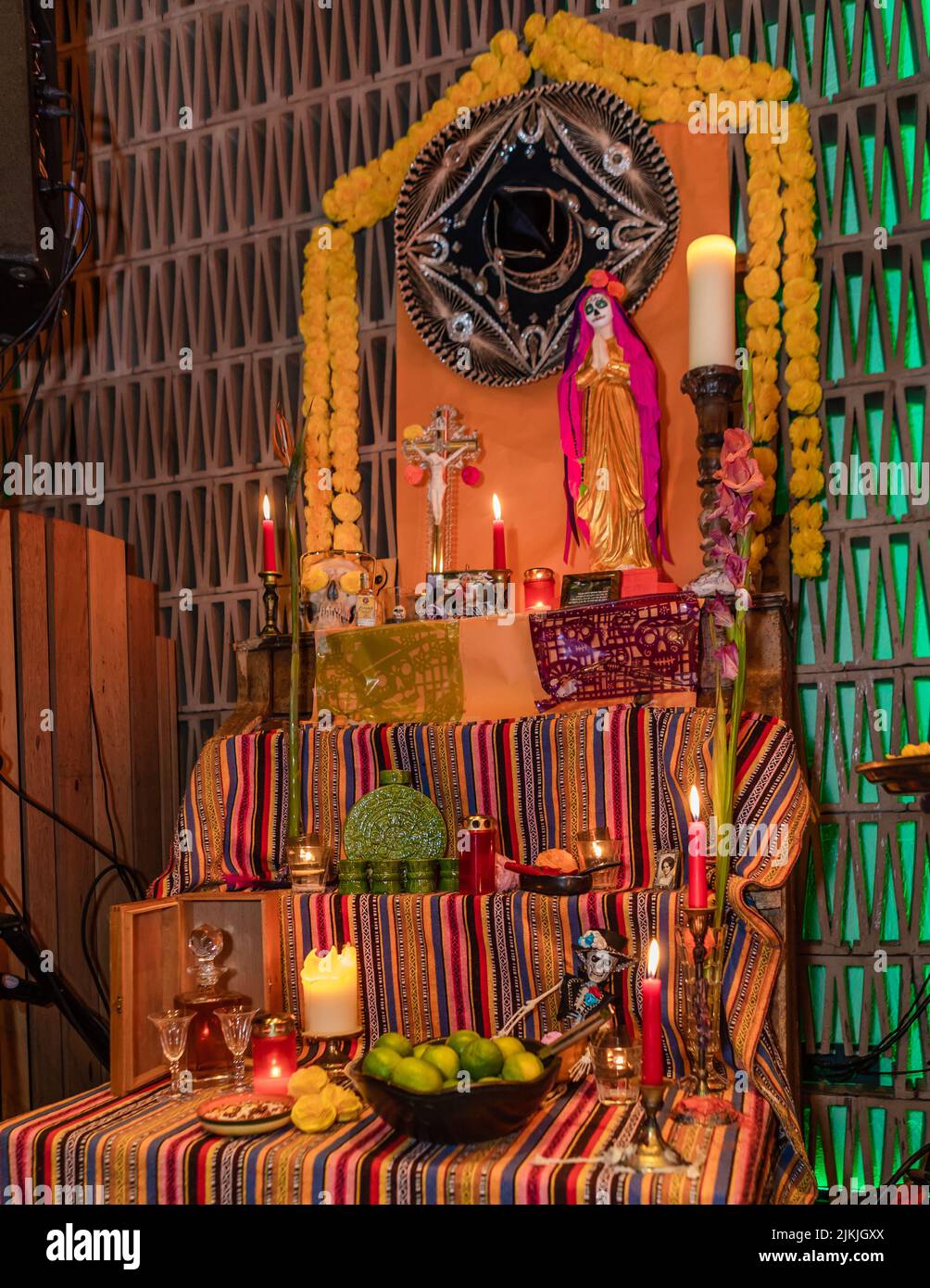 Eine vertikale Aufnahme eines religiösen Rituals mit Kerzen, Kreuz und Früchten Stockfoto