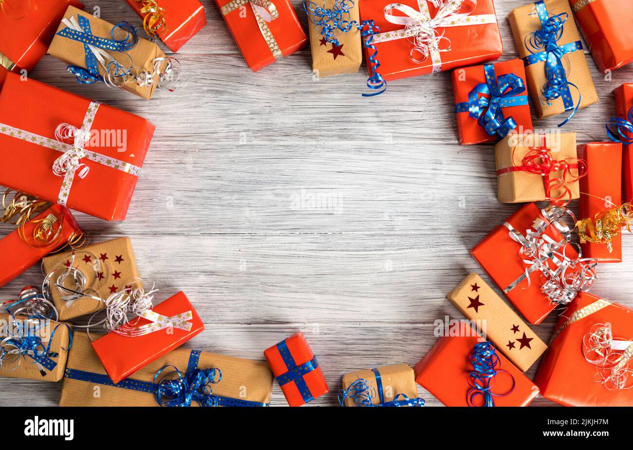 Eine Draufsicht auf Weihnachtsgeschenke auf einem Holztisch mit Kopieplatz in der Mitte Stockfoto