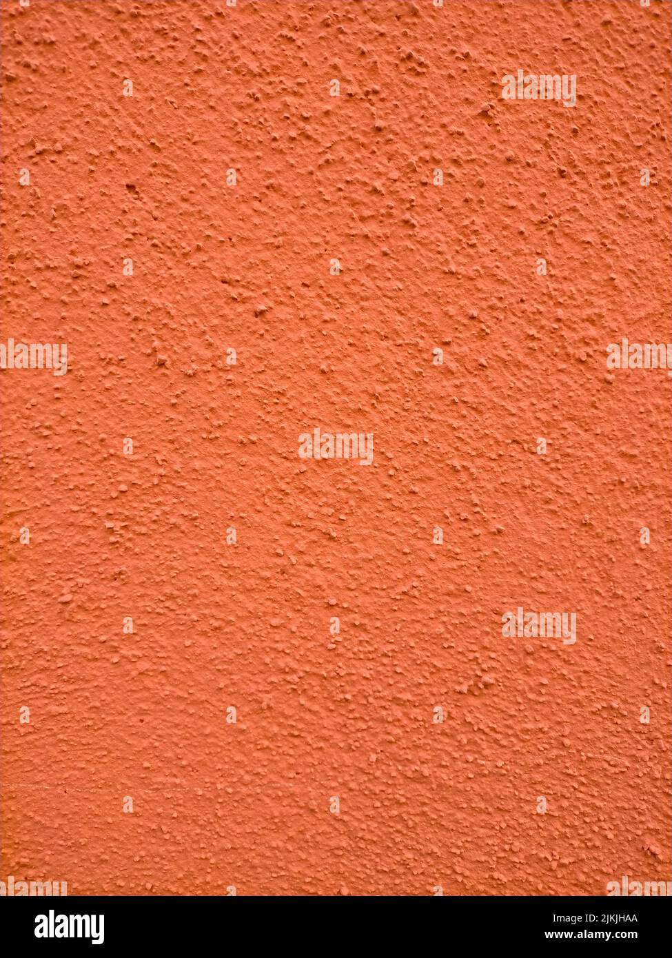 Eine orangefarbene Steinwandstruktur mit Kopierfläche Stockfoto
