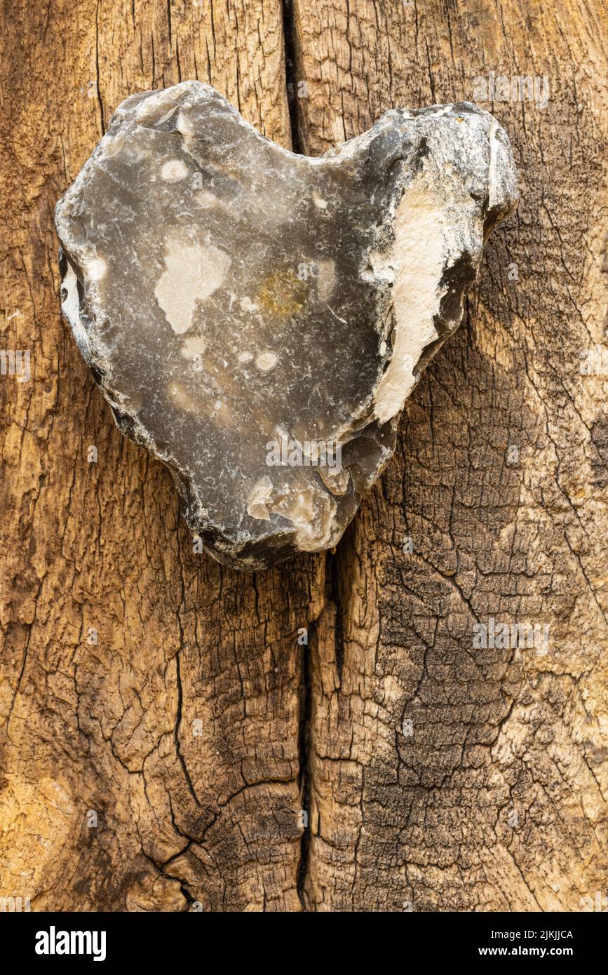 Herzförmiger Stein auf Holzgrund, Stillleben Stockfoto