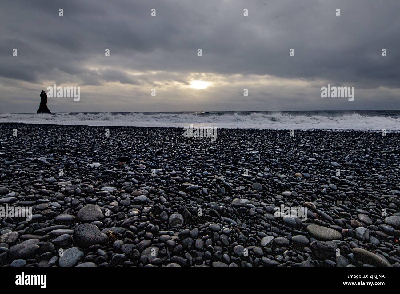 Eine malerische Aussicht auf starke Wellen an einem felsigen Strand unter einem düsteren Himmel Stockfoto