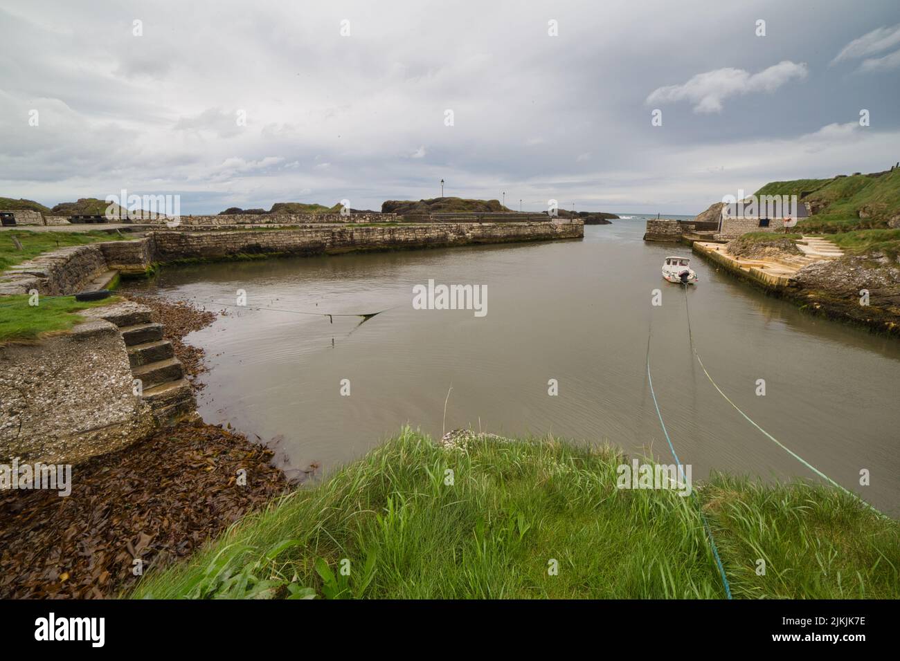 Eine wunderschöne Aufnahme des Hafens von Ballintoy unter stürmisch bewölktem Himmel in Ballintoy, Nordirland, Großbritannien Stockfoto