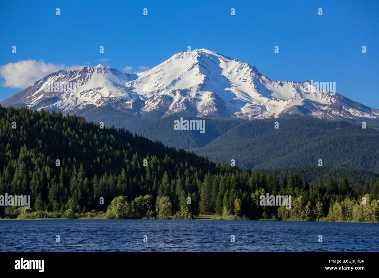 Eine malerische Aussicht auf den Mount Shasta mit einem Vordergrund von Bäumen bedeckten Hügeln und einem Gewässer Stockfoto