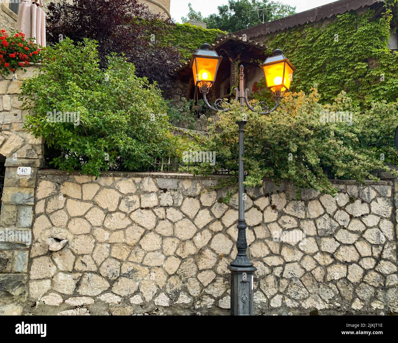 In der Dämmerung ein alter Straßenlaternen auf einer alten Mauer Stockfoto