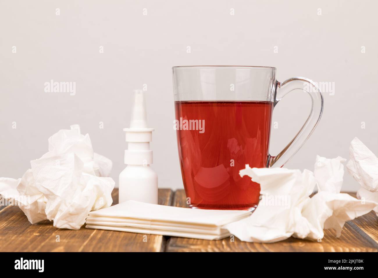Eine Nahaufnahme einer Tasse Tee, Nasenspray und Taschentücher für Krankheit Stockfoto