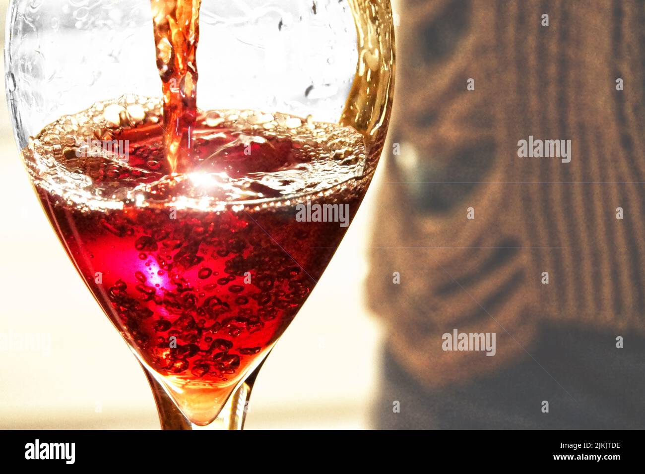 Eine Nahaufnahme von Rotwein, der in das Glas gegossen wird Stockfoto