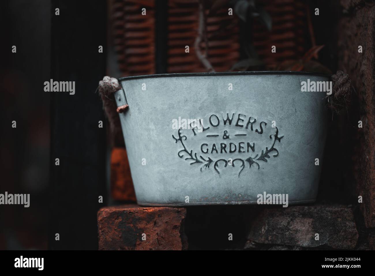 Eine selektive Aufnahme eines alten Metalleiters mit dem Schild „Blumen und Garten“ Stockfoto