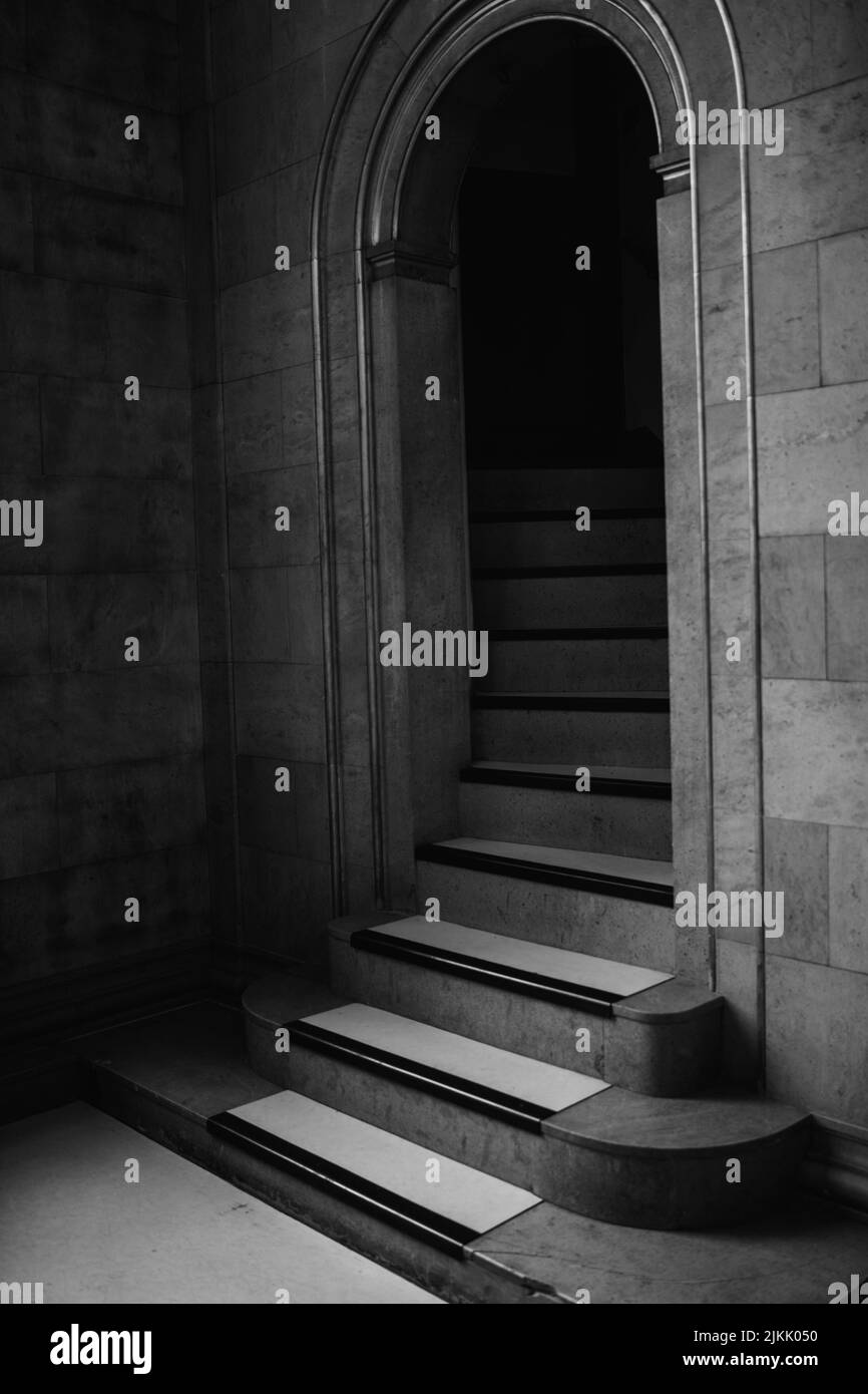 Eine vertikale Aufnahme einer Wendeltreppe aus Stein, eingerahmt von einem gewölbten Steineingang Stockfoto Eine vertikale Aufnahme einer Wendeltreppe aus Stein, eingerahmt von einem gewölbten Steineingang Stockfoto