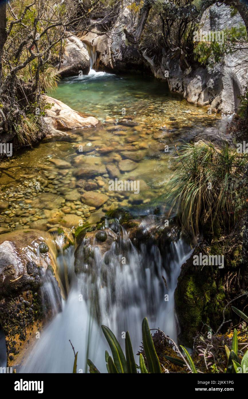 Eine schöne Landschaft Blick auf einen kleinen Teich und Wasserfälle auf dem Berg in hellem Sonnenlicht Stockfoto