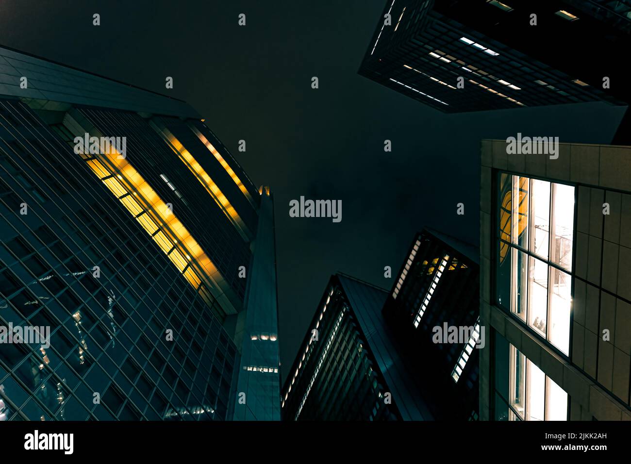 Ein niedriger Winkel von modernen Wolkenkratzern, die von Lichtern gegen den Nachthimmel beleuchtet werden Stockfoto