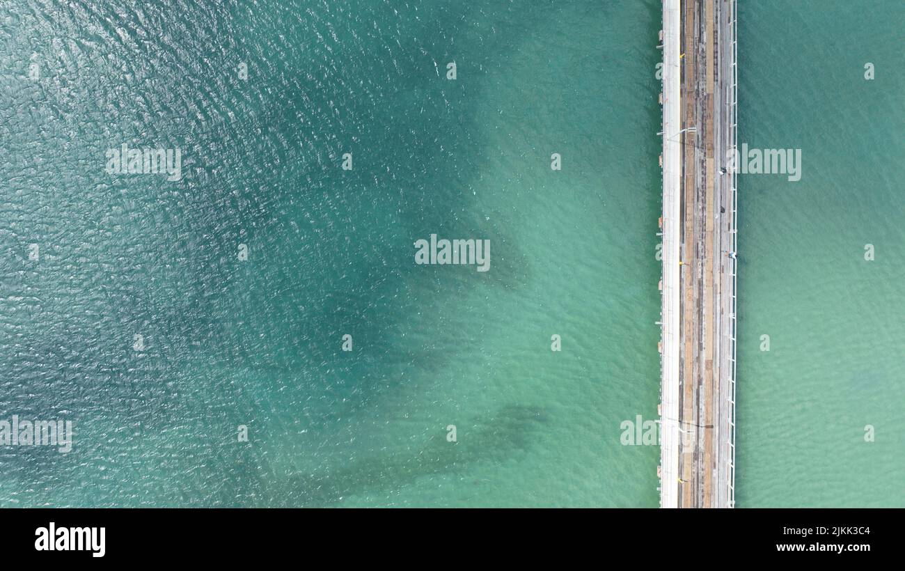 Eine Luftaufnahme des Holzweges über dem schönen klaren Wasser Stockfoto