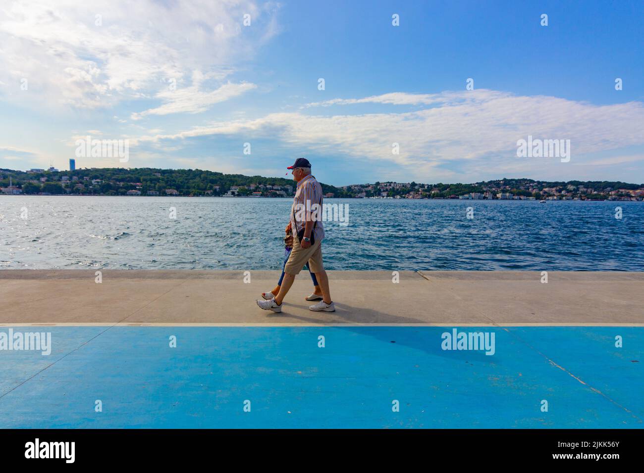 Das ältere Paar ging Hand in Hand am Strand am Meer. Istanbul, Türkei. Stockfoto