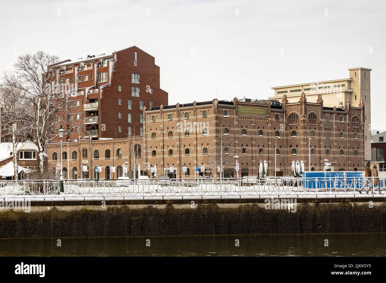 Ehemaliges Fabrikgebäude hinter dem Kai von Utrecht Leidsche Rijn Kanal Boulevard bedeckt mit Schnee mit Wohnturm daneben Stockfoto