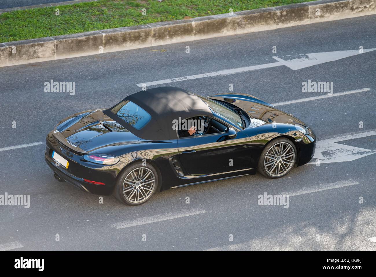 Ein schwarzer Porsche 718 Luxuswagen auf den Straßen von Lissabon, Portugal Stockfoto