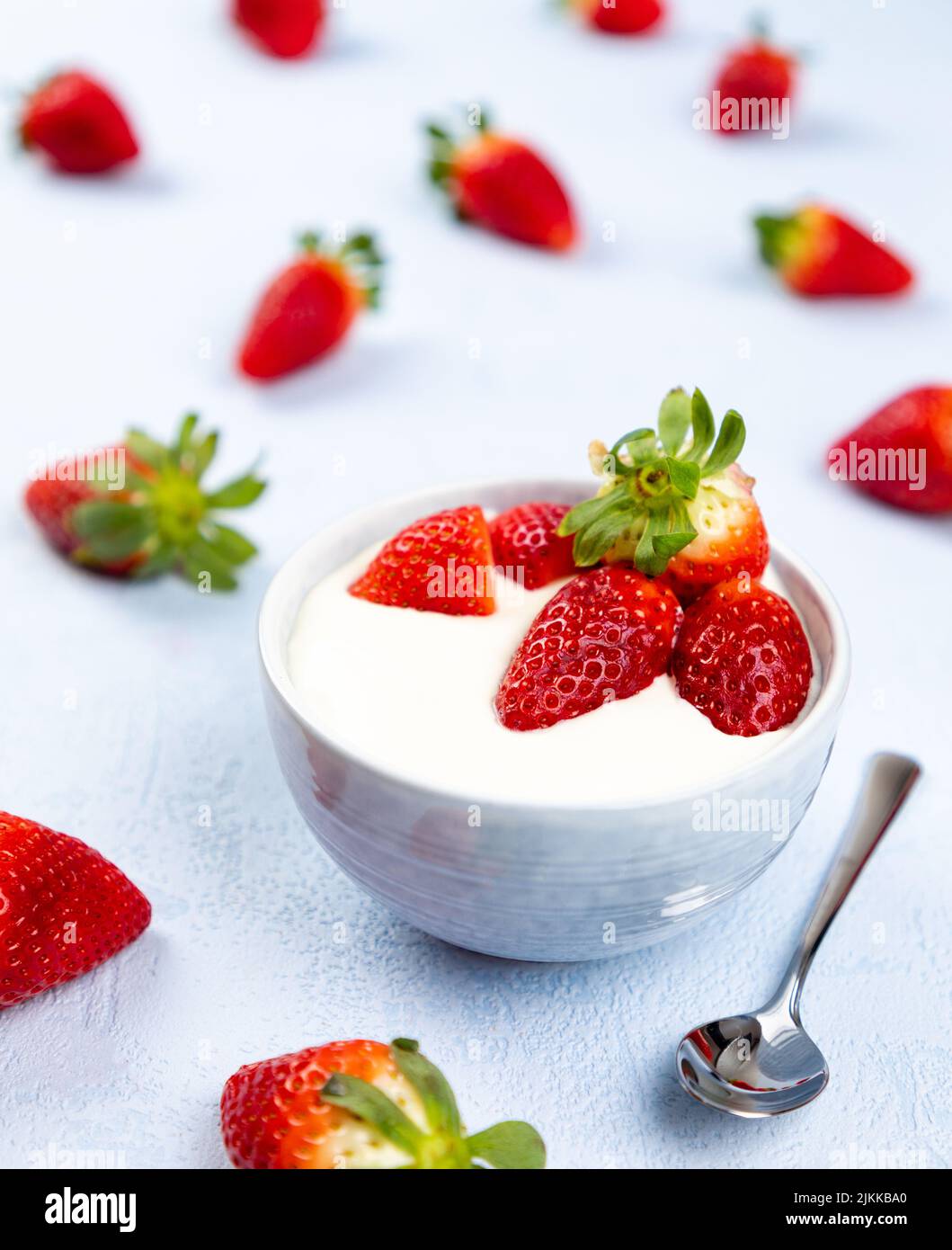 Creme-Dessert mit Erdbeerfrucht in einer Schüssel auf blauem Hintergrund Stockfoto