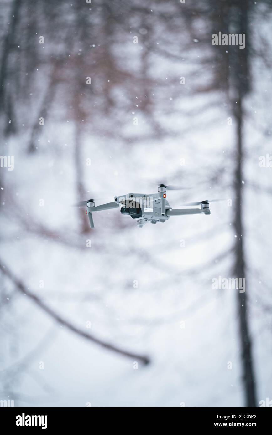 Die DJI-Drohne fliegt über den verschneiten Wald Stockfoto
