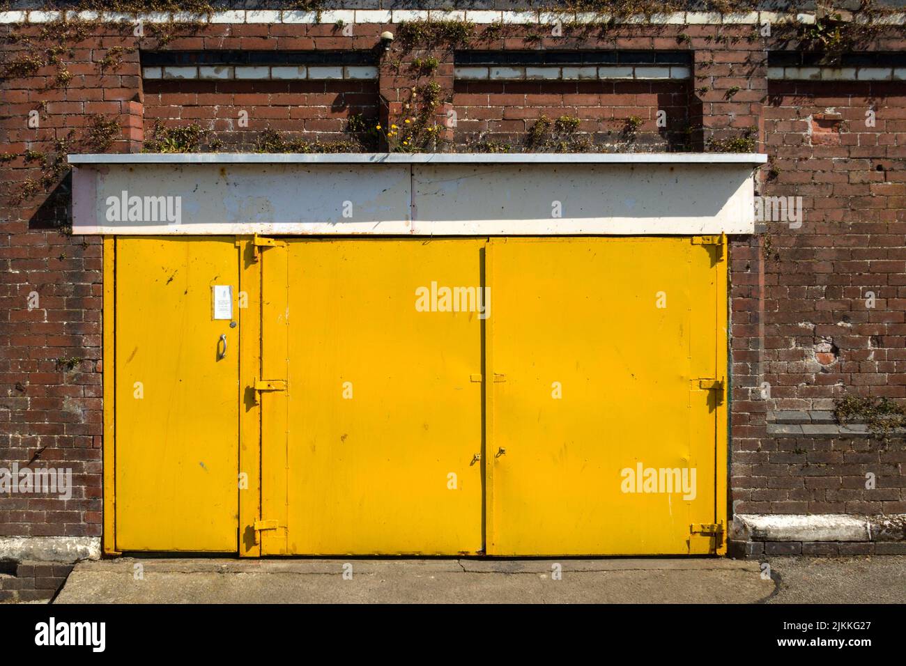 Eine Aufnahme von gelben Metalltüren eines Backsteingebäudes Stockfoto