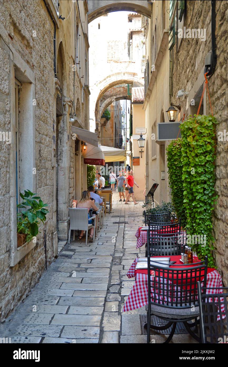 Eine vertikale Ansicht eines Cafés im Freien in einer engen Straße in Split, Kroatien Stockfoto