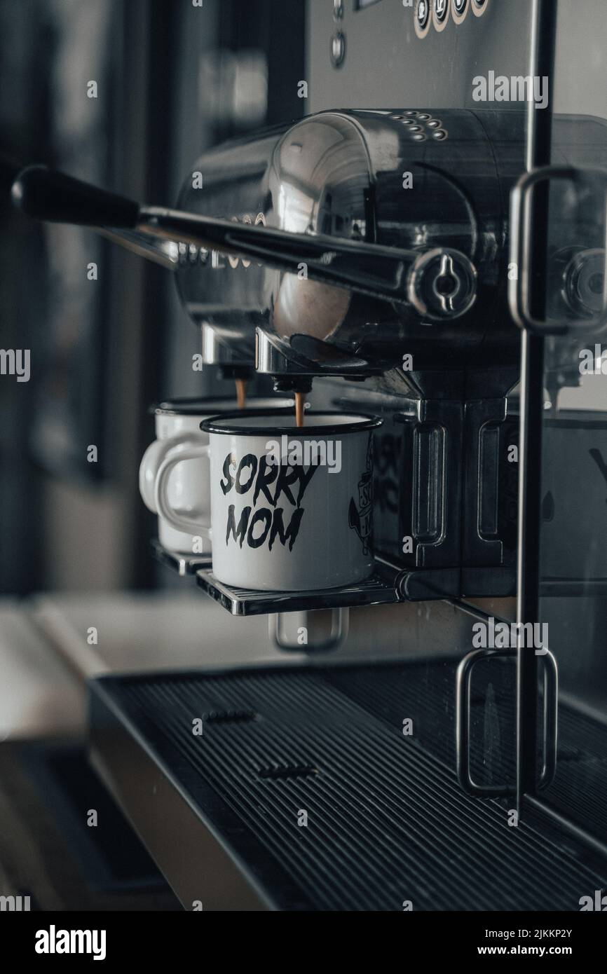 Zwei weiße Tassen unter der Kaffeemaschine Stockfoto