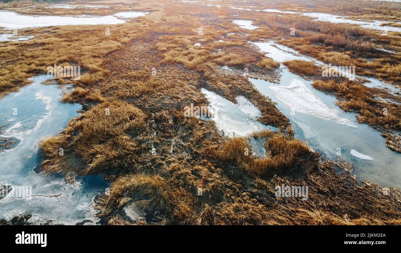 Ein kühlender Blick auf schmelzenden Schnee auf einem Feld an einem hellen sonnigen Tag Stockfoto