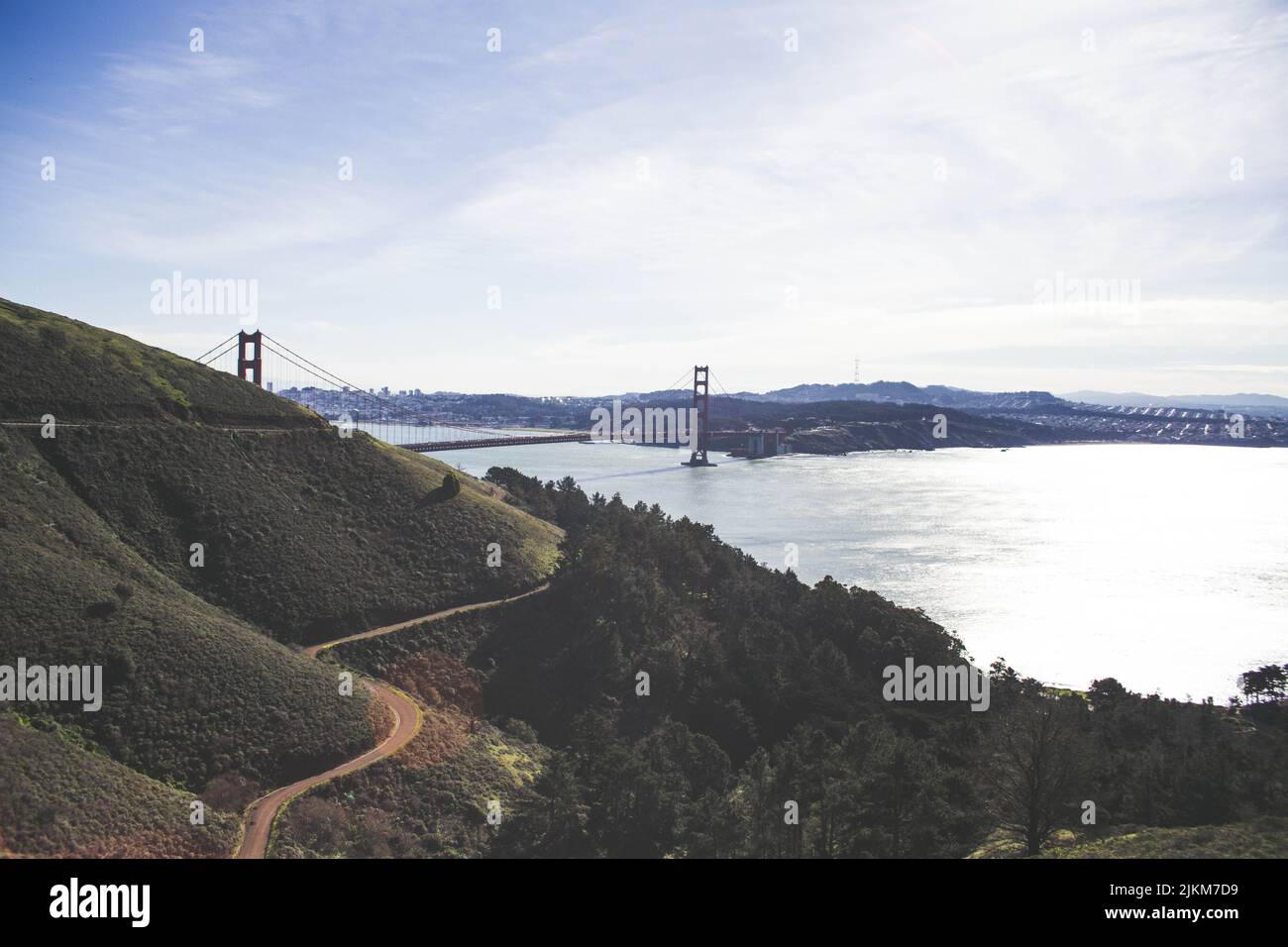 Eine schmale Autobahn inmitten von Bäumen und einem Berg auf dem Hintergrund der Golden Gates Brücke Stockfoto