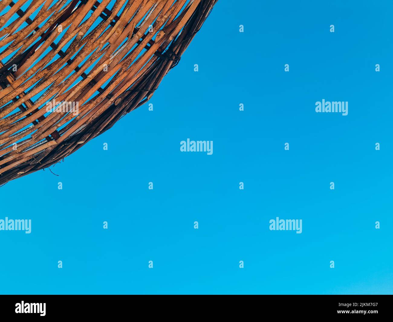 Bambus-Sonnenschirm auf blauem Himmel Hintergrund Stockfoto
