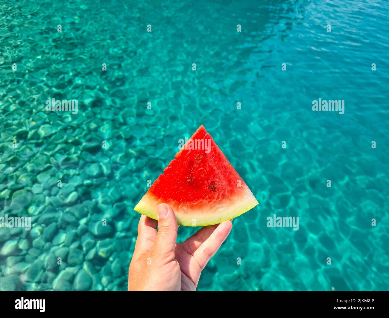 Leuchtend rote Wassermelone auf blauem Meeresgrund. Stockfoto