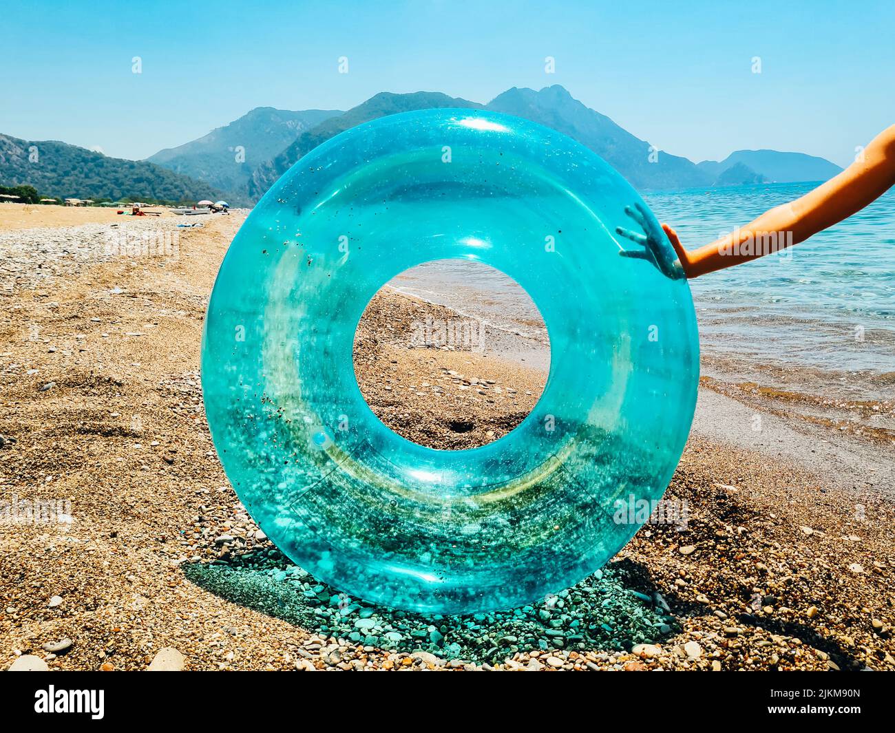 Blauer aufblasbarer Schwimmring und Sonnenbrillen am Strand. Stockfoto