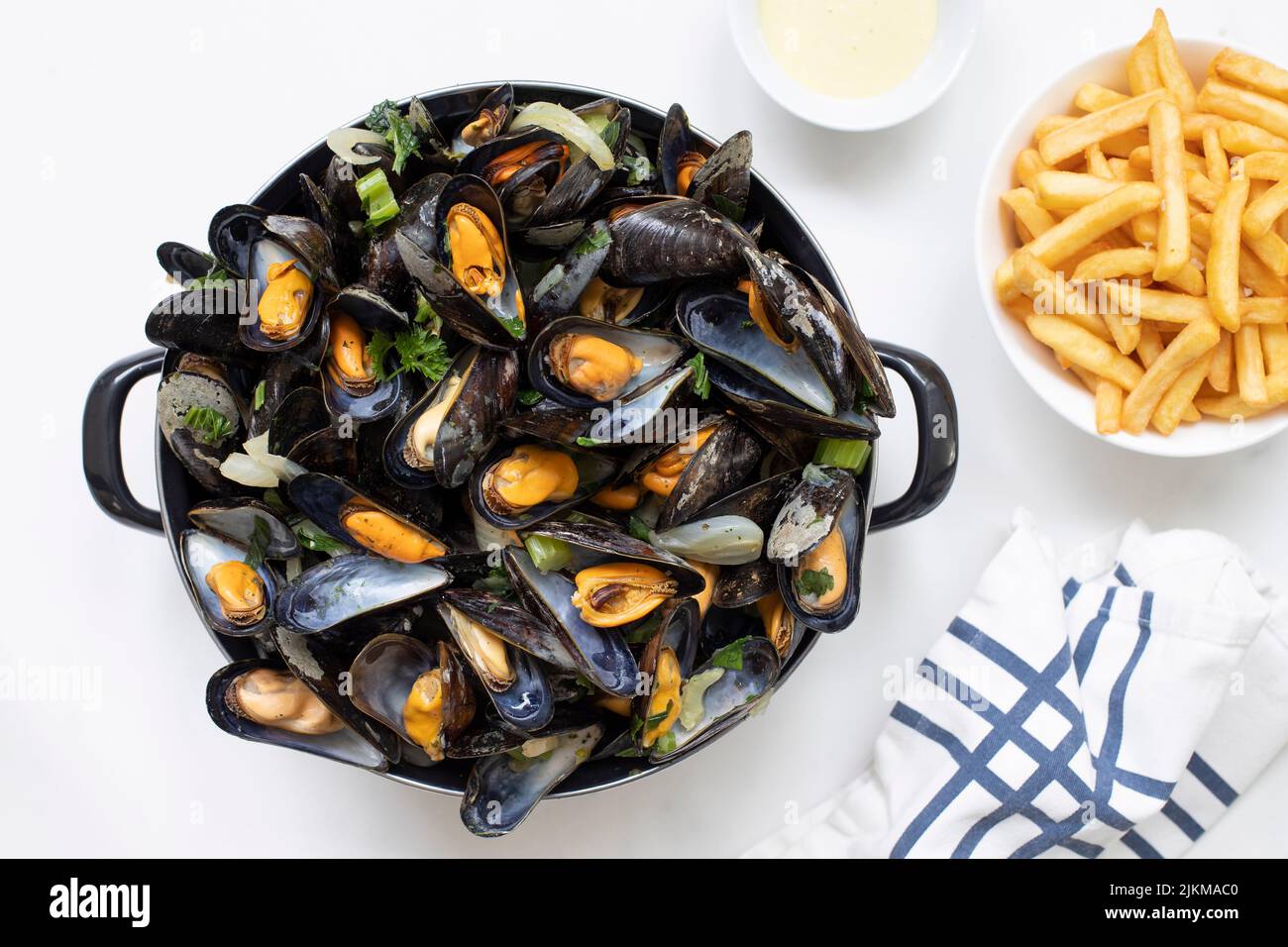 Eine Draufsicht auf belgische Muscheln mit gebratenen Pommes frites und Sauce auf einem weißen Marmortisch Stockfoto