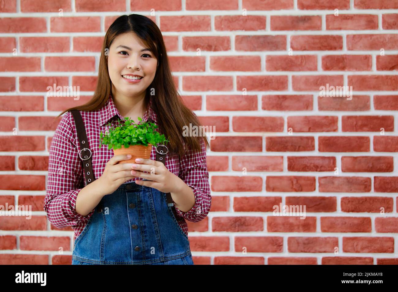 Nahaufnahme einer südostasiatischen Frau mit Blumentopf Stockfoto