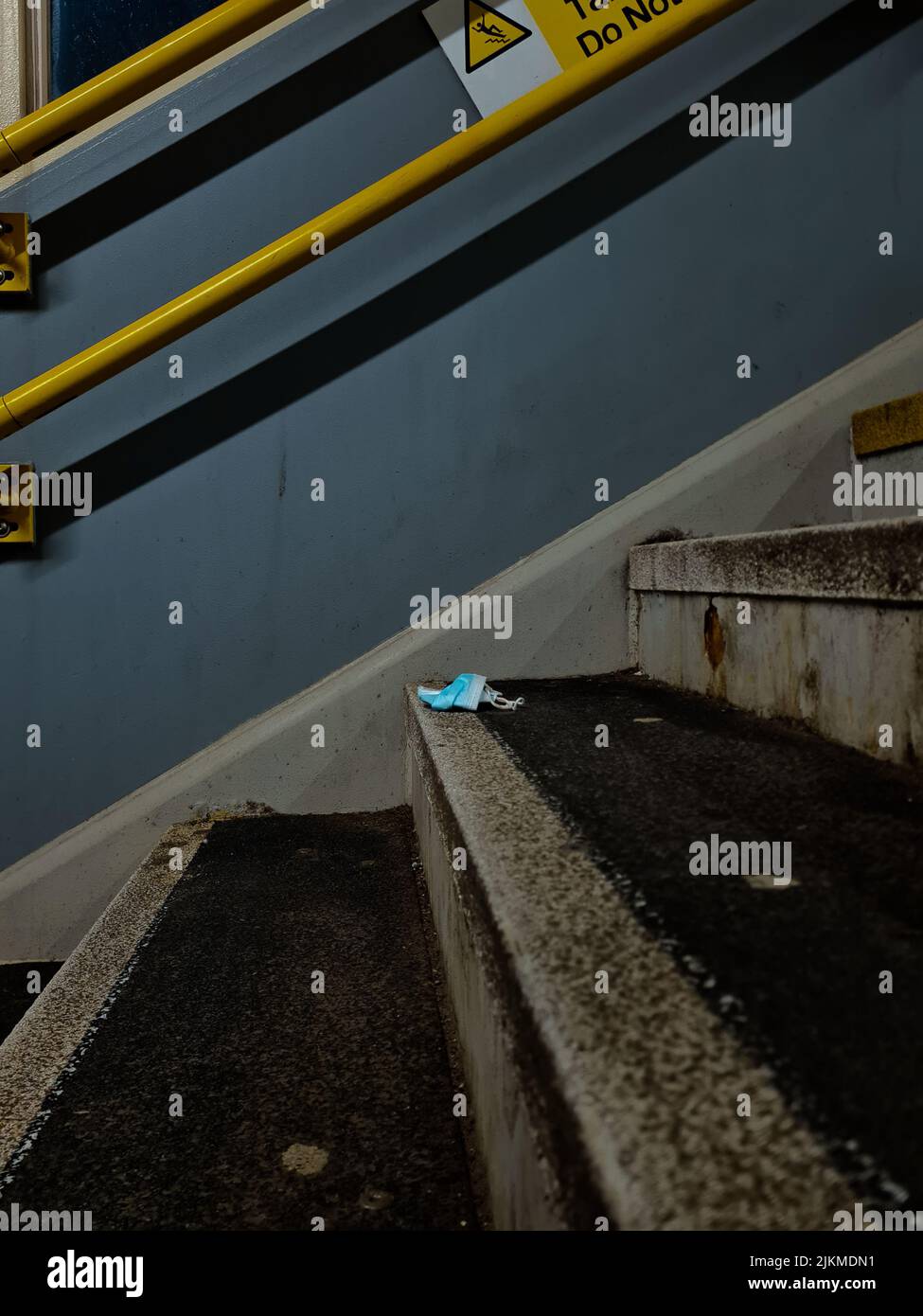 Eine Nahaufnahme einer gebrauchten Maske fiel auf schmutzige Treppen Stockfoto