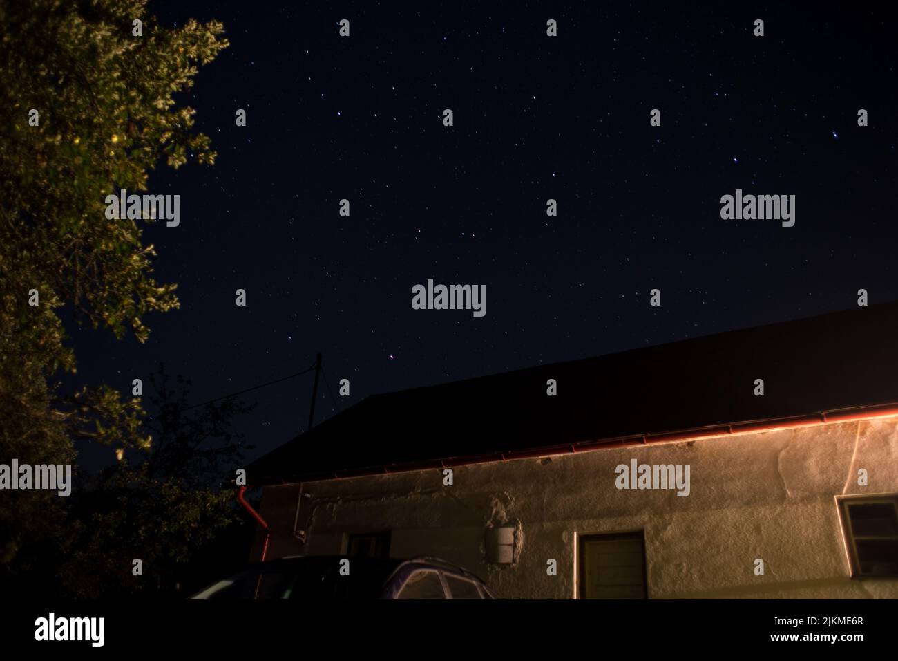 Eine Aufnahme eines sternenklaren Nachthimmels über einem Haus Stockfoto
