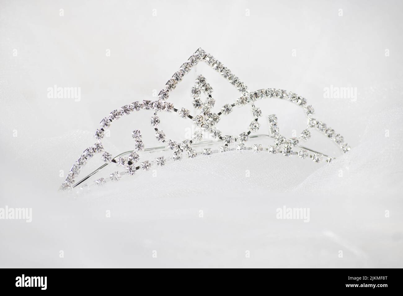 Eine Nahaufnahme einer silbernen Krone mit Edelsteinen auf weißem Hintergrund Stockfoto