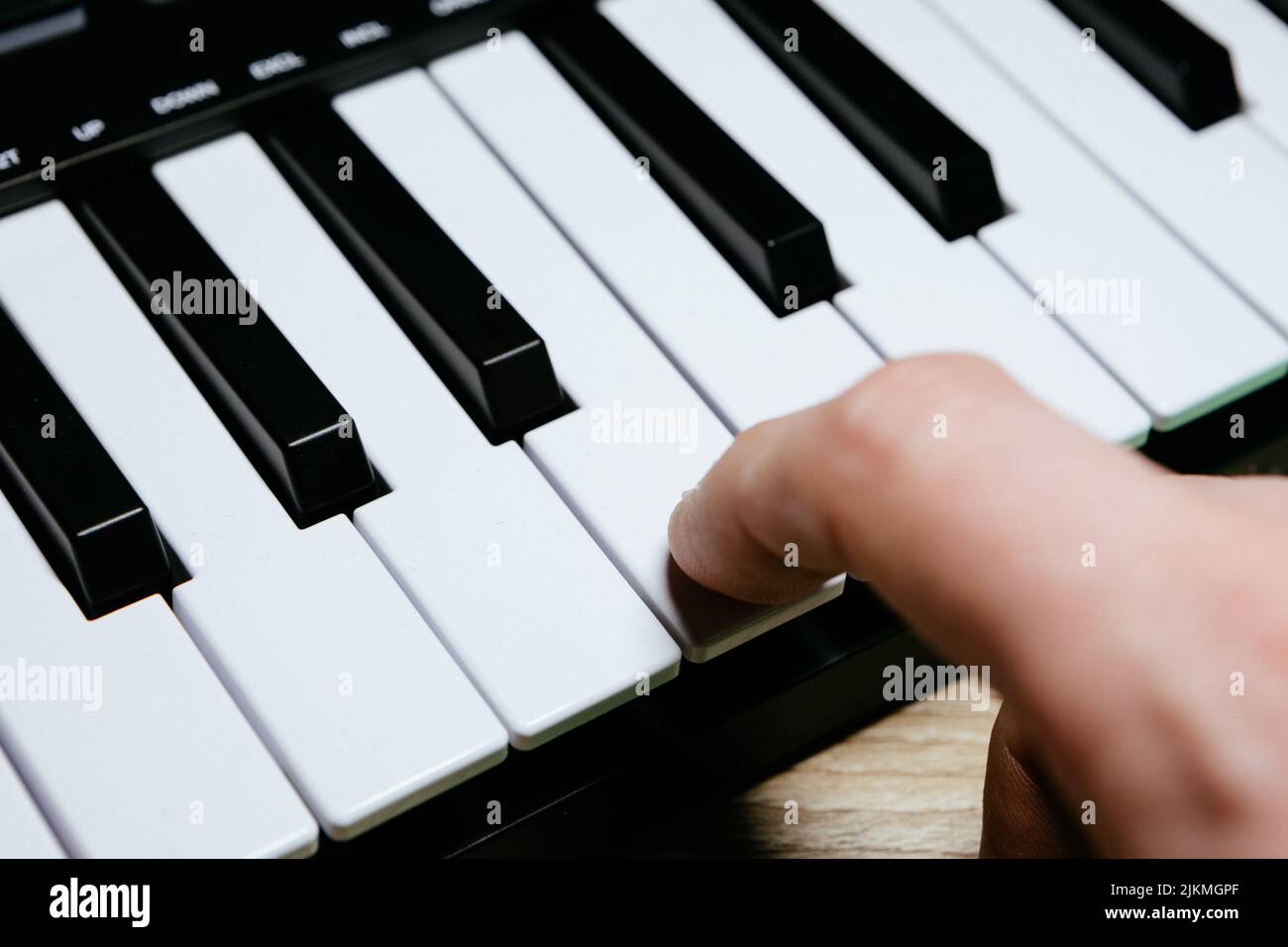 Ein Finger auf dem Klavierschlüssel Stockfoto