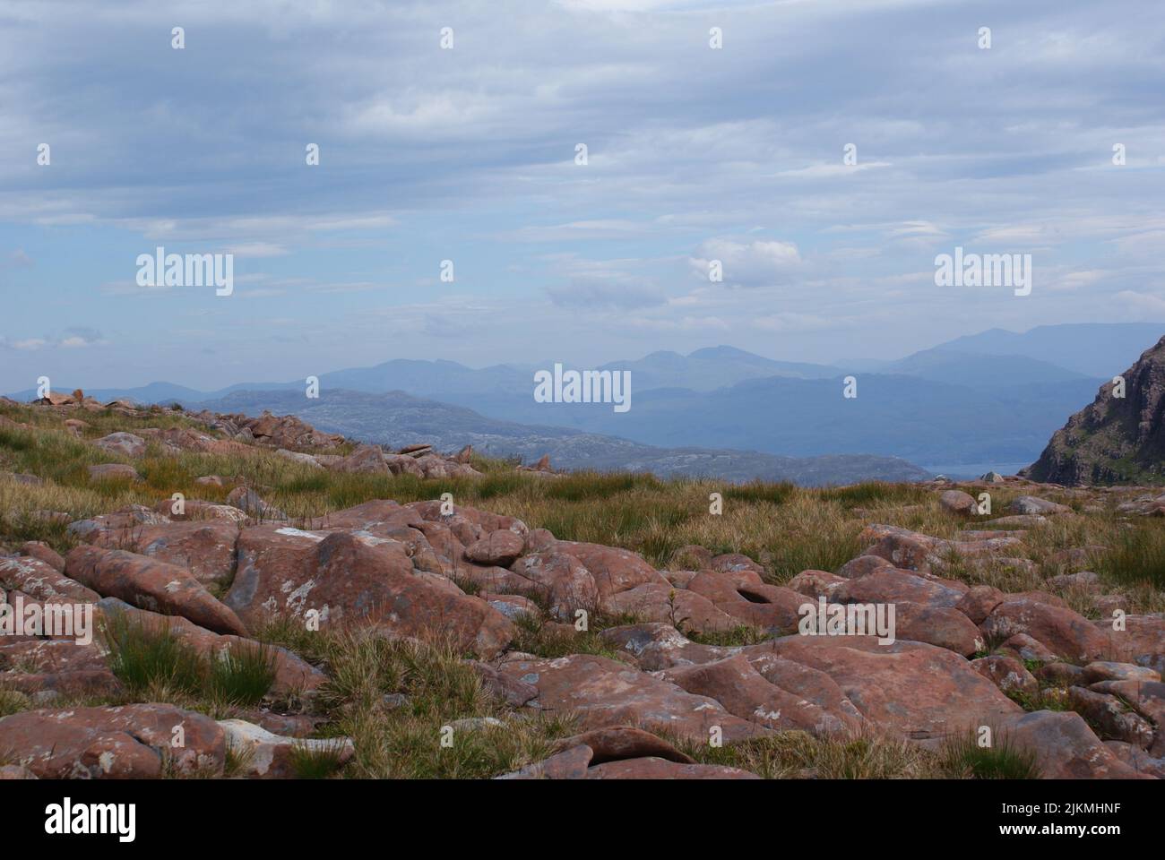Eine schöne Aufnahme von einigen riesigen Felsen auf dem Boden, umgeben von Grassträuchern. Stockfoto