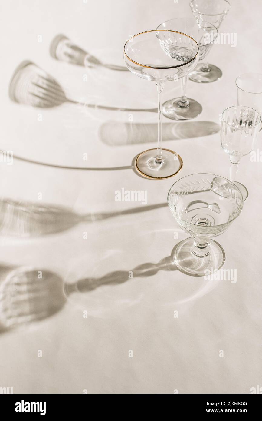 Sammlung von verschiedenen leeren Cocktailgläsern auf weißem Hintergrund mit Schatten Stockfoto