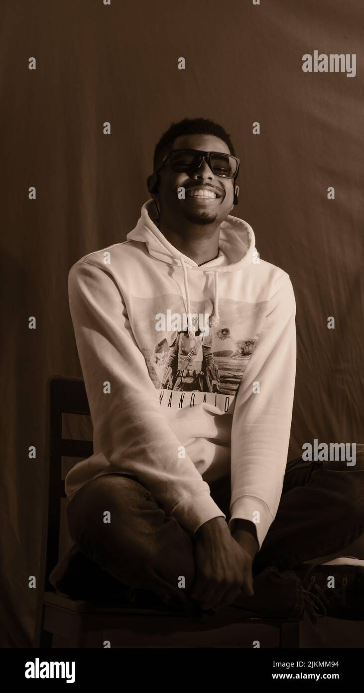 Ein cooler, fröhlicher junger afroamerikanischer Junge, der in einem Studio posiert Stockfoto