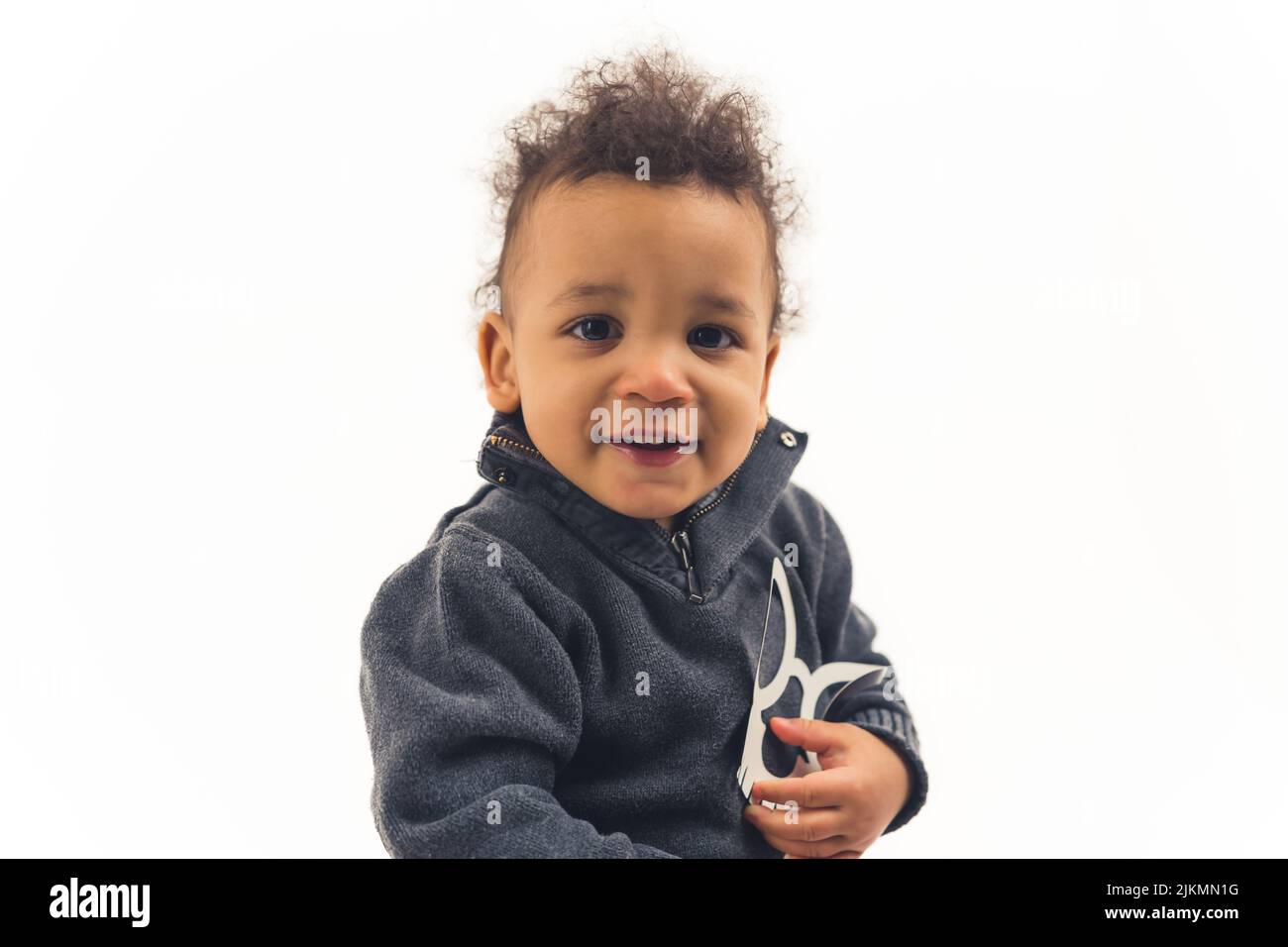 Kleiner afroamerikanischer 5-jähriger Junge, der eine Skelettmaske hält und die Kamera anschaut - Nahaufnahme isoliert. Hochwertige Fotos Stockfoto