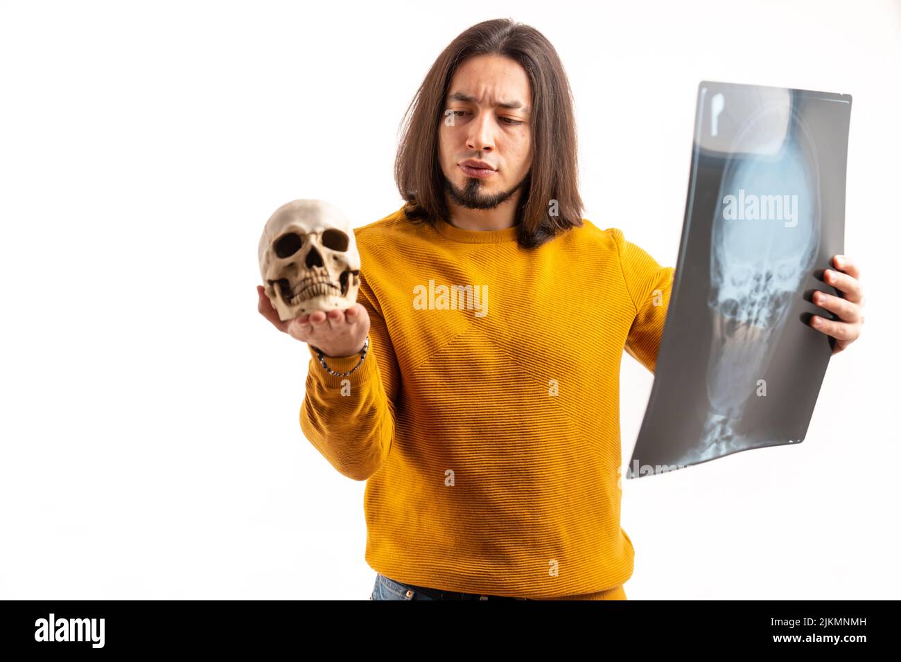 Isolierte gesunde bärtige lateinische Person in seinem 30s hängen ein Röntgenbild und den menschlichen Schädel. Hochwertige Fotos Stockfoto