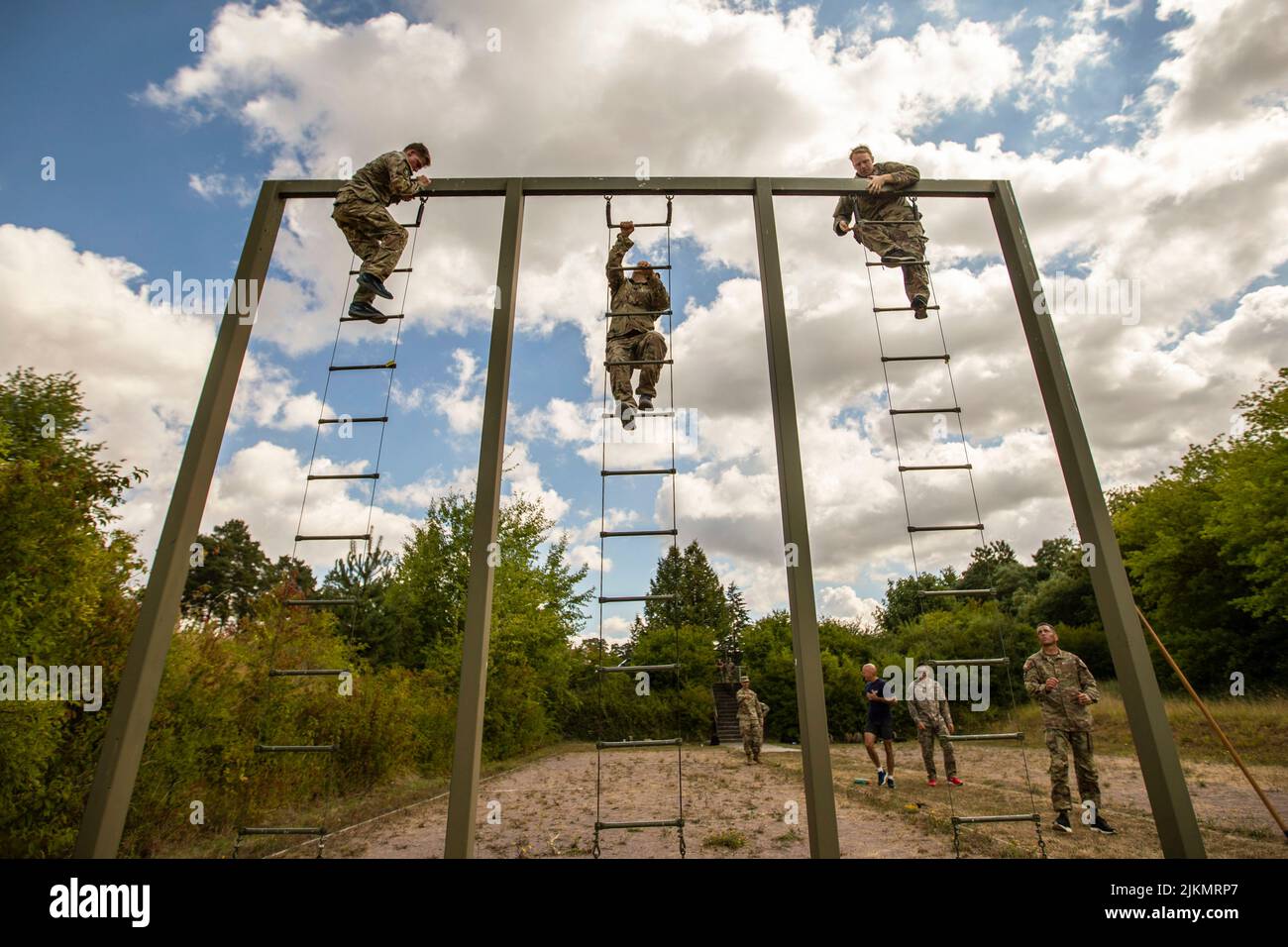 26. Juli 2022 - Deutschland - CIOR-Mitbewerber, Army Reserve CPL. Ethan Allen, Army Reserve Medical Command (links), Army Reserve Capt. Thomas Wheeler, 807.Medical Command (Deployment Support) (Mitte) und Army Reserve Capt. Justin Weeks, 75. Innovation Command, skaliert am 26. Juli 2022 Leitern auf einem Hindernisparcours in der Nähe von Hammelburg, Deutschland. Der militärische Wettbewerb der Interalliierten Föderation der Reserveoffiziere (CIOR MILCOMP) ist ein dreitägiger Teamwettbewerb, der aus der NATO und den Partnership for Peace Nations in Europa besteht. Es gibt es seit 1957. Der Wettbewerb steht allen Reservekomponenten offen Stockfoto