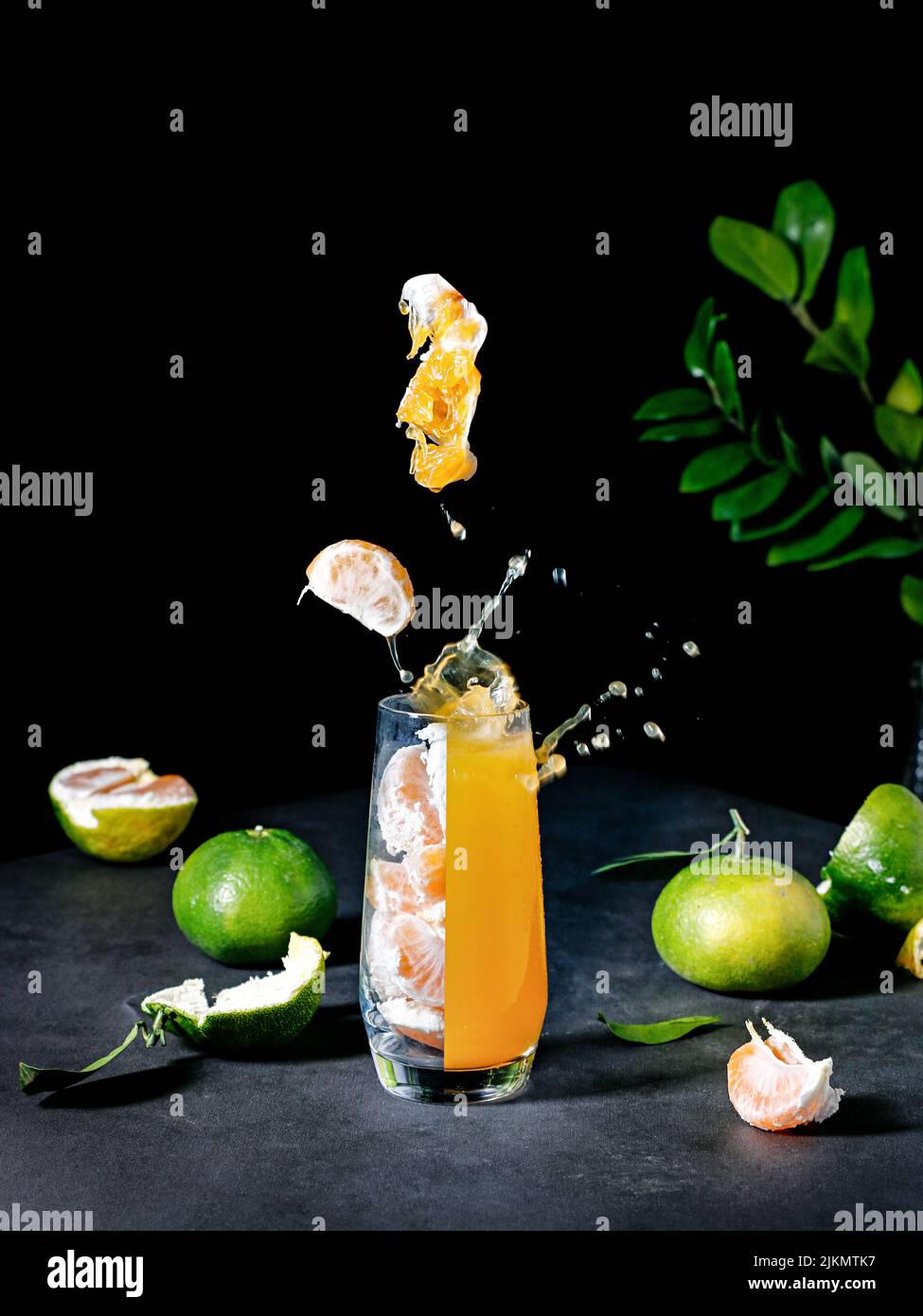 Eine vertikale Aufnahme des Mandarinensaftes und der grünen Blätter Stockfoto