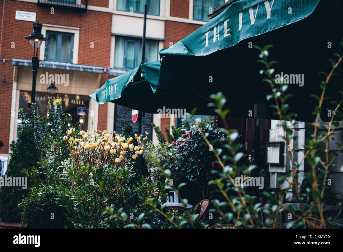 Eine wunderschöne Aufnahme des Restaurants Ivy in Covent Garden London, Großbritannien, mit einem Apartmentgebäude im Hintergrund Stockfoto