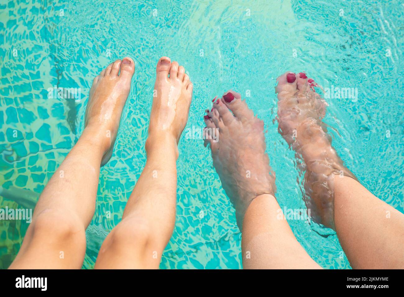 Wassertemperatur im Schwimmbad mit Füssen im Sommer Stockfoto